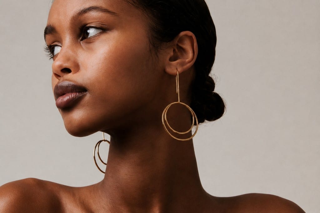 Model wearing layered gold hoop earrings — statement jewelry from Undaunted Treasure Trove